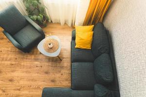 Top down view cozy apartment living room with sofa and yellow pillows stylish table with autumn flower by window.Fall autumn colors palettes photo