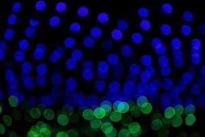 Efectos de luz bokeh abstractos de desenfoque verde azul en la textura de fondo negro nocturno foto