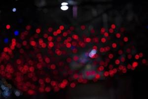 Desenfoque rojo abstracto efectos de luz bokeh en la textura de fondo negro de la noche foto