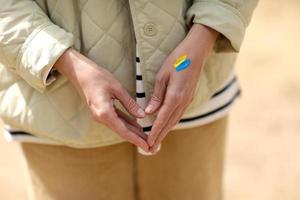 Stop War. Peace in Ukraine. woman with picture of flag of ukraine on hand. Antiwar support concept. High quality photo. photo