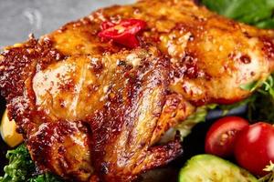 Pollo entero glaseado asado con verduras frescas foto