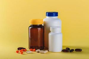 Bottle and Pills on yellow Background. Medicine Healthcare Pharmacy Concept. Coronavirus. photo
