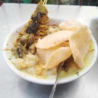 Chicken porridge is the Indonesian people's favorite breakfast served with rice crackers photo