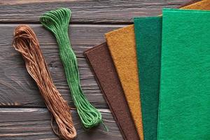 Materials for autumn crafts with children. Felt and threads on a wooden background photo