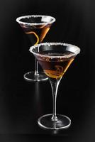 Martinis de cítricos de naranja sobre fondo negro foto