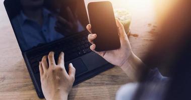 Businessman hands working with finances about cost and calculator and laptop with tablet, smartphone at office in morning light photo