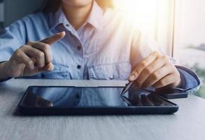 Businessman hands working with finances about cost and calculator and laptop with tablet, smartphone at office in morning light photo