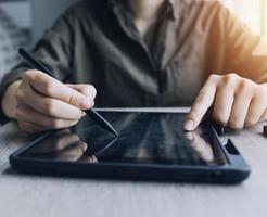 Businessman hands working with finances about cost and calculator and laptop with tablet, smartphone at office in morning light photo