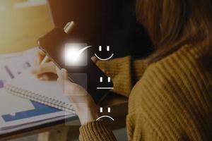 Satisfaction and Customer service concept ,Business people are touching the virtual screen on the happy Smiley face icon to give satisfaction in service. rating very impressed. photo