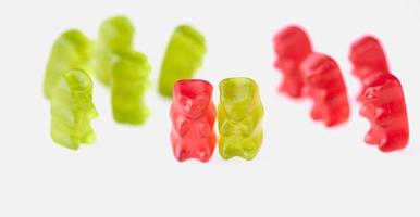 green gummy bears on the left and red gummy bears on the right side and one pair together photo