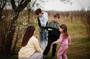 Mother with kids working in spring garden. photo