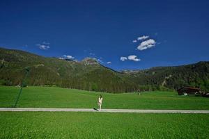 mujer de pie en el camino en la pradera alpina en untertauern, austria. foto