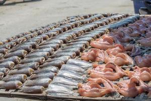 Dried fishes on wooden racks photo