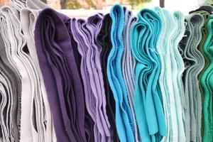 Detailed close up view on samples of cloth and fabrics in different colors found at a fabrics market photo