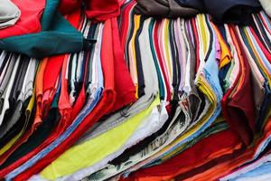Detailed close up view on samples of cloth and fabrics in different colors found at a fabrics market photo