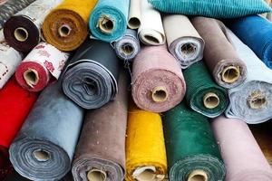 Detailed close up view on samples of cloth and fabrics in different colors found at a fabrics market photo