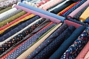Detailed close up view on samples of cloth and fabrics in different colors found at a fabrics market photo