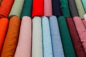 Detailed close up view on samples of cloth and fabrics in different colors found at a fabrics market photo