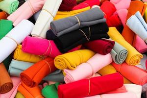 Detailed close up view on samples of cloth and fabrics in different colors found at a fabrics market photo