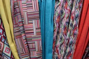 Detailed close up view on samples of cloth and fabrics in different colors found at a fabrics market photo