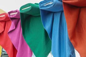Detailed close up view on samples of cloth and fabrics in different colors found at a fabrics market photo