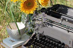 Sunflowers With A Vintage Typewriter, A Stack Of Books, And A Tea Cup photo