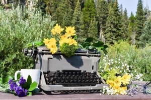 Vintage Typewriter With Yellow Flowers And A Mug In The Mountains photo