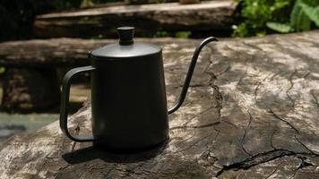 The drip coffee set includes coffee beans, drip kettle and a coffee grinder.  place on wooden table. photo