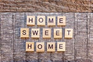 inscripción hogar dulce hogar letras palabra sobre fondo de madera foto
