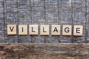 Inscription VILLAGE letters word on wooden background photo