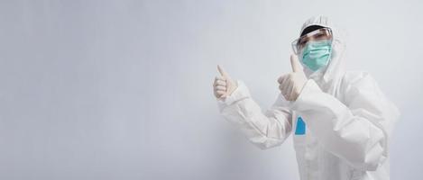 Doctor in PPE suit gesture make hand sign. Represent victory win over virus. photo