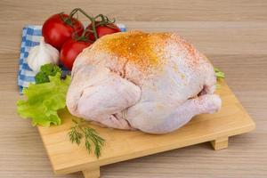 Raw chicken on wooden board and wooden background photo