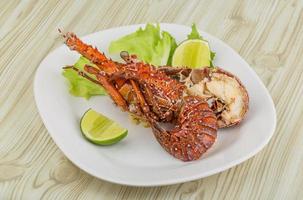 Spiny lobster on the plate and wooden background photo