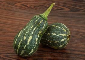 Green pumpkin on wooden background photo