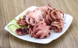 Marinated octopus on the plate and wooden background photo
