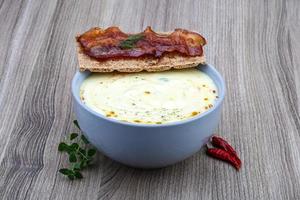 Cheese soup in a bowl on wooden background photo