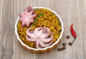 Seafood risotto in a bowl on wooden background photo