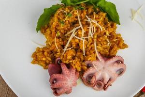 Seafood risotto on the plate and wooden background photo