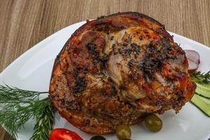 Pork knee on the plate and wooden background photo