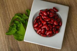 frijoles en un recipiente sobre fondo de madera foto