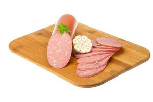 Sausages on wooden board and white background photo