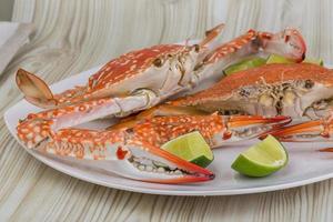 Boiled crabs on the plate and wooden background photo