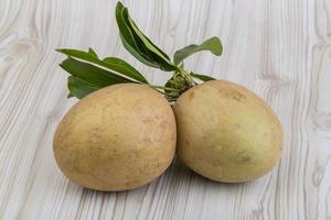 Sapodilla on wooden background photo