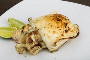 Grilled cuttlefish on the plate and wooden background photo