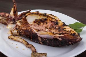 Grilled cuttlefish on the plate and wooden background photo