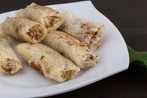 Spring rolls on the plate and wooden background photo