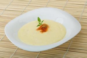 Cheese soup on the plate and wooden background photo