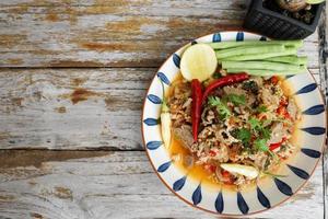 Spicy minced pork salad served with fresh vegetables Minced pork salad is a popular traditional Thai food of Thailand. Spicy Minced Pork Salad is also called Larb Moo. photo