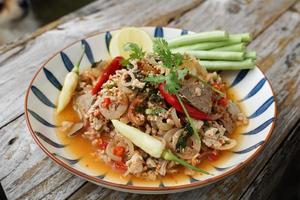 Spicy minced pork salad served with fresh vegetables Minced pork salad is a popular traditional Thai food of Thailand. Spicy Minced Pork Salad is also called Larb Moo. photo
