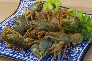 Raw Crayfish on the plate and wooden background photo